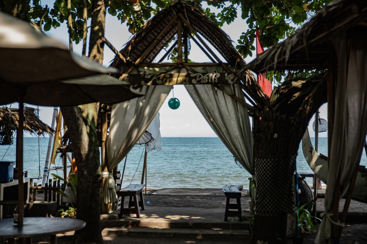 Relaxing beachfront gazebo setting in Bali with ocean views.